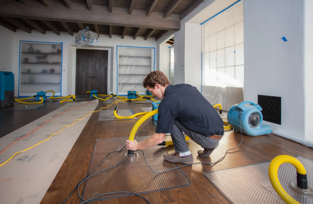 Technician restoring water damaged wood flooring