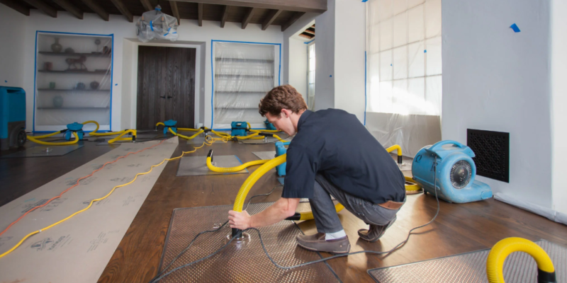 Technician restoring water damaged wood flooring